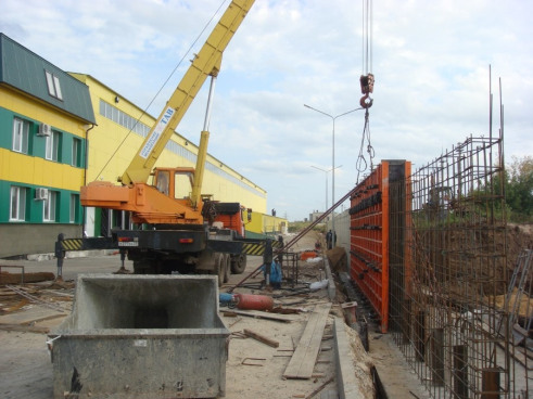 Автокран 25 тонн ведет работы по устройству монолитной стены на территории логистического центра